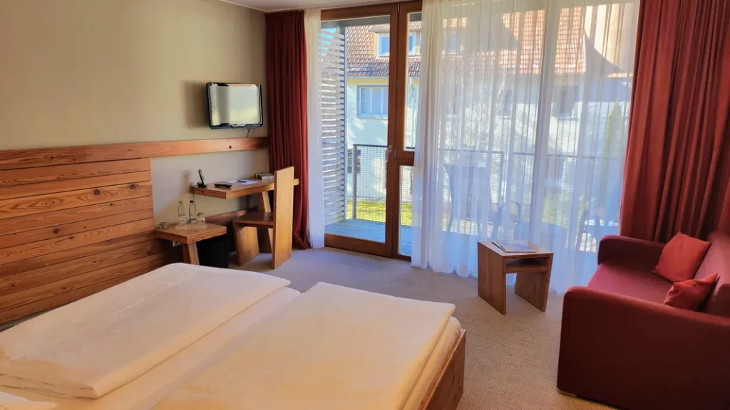 Helles Hotelzimmer im Hopfenhimmel der Speidel’s BrauManufaktur mit Balkon, warmem Holzdesign und gemütlicher Atmosphäre auf der Schwäbischen Alb